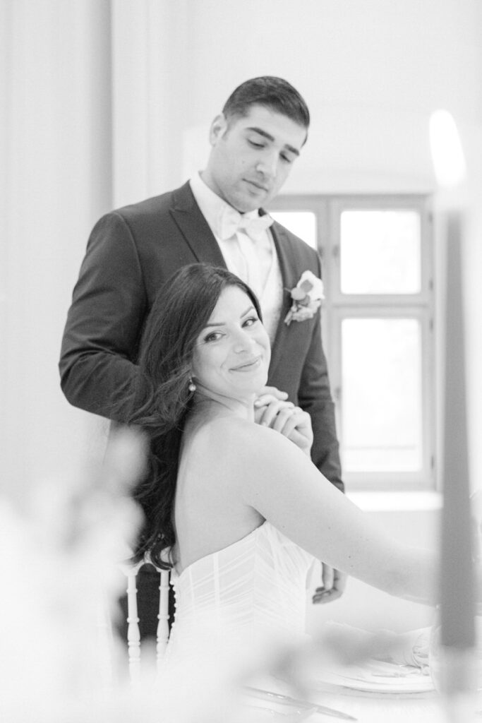 Braut lächelt in die Kamera des Hochzeitsfotografen während der Bräutigam ihre Hand hält