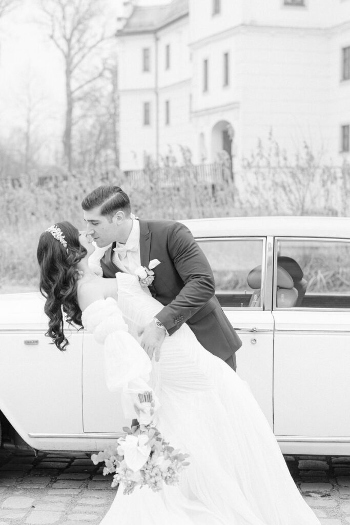 Hochzeitspaar küsst sich beim Brautpaarshooting vor einer Schlosskulisse bei ihrer Hochzeit im Schloss Hohenkammer