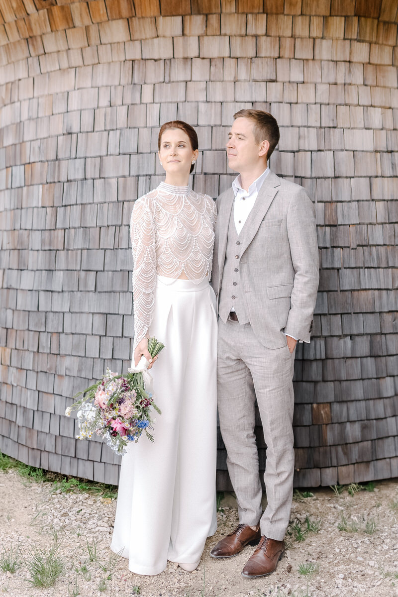Modern gekleidetes Brautpaar mit einem bunten Brautstrauß beim Paarshooting in Berchtesgaden