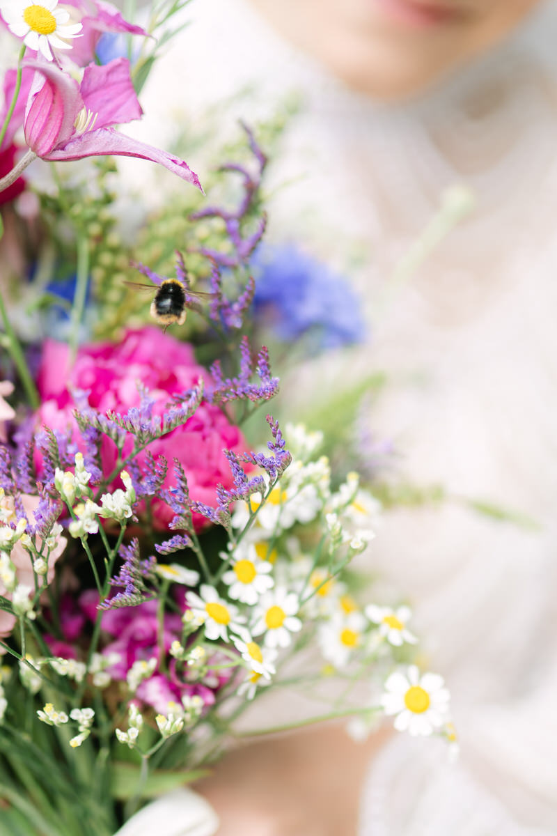 Nahaufnahme einer Hummel, die auf einen Brautstrauß zufliegt