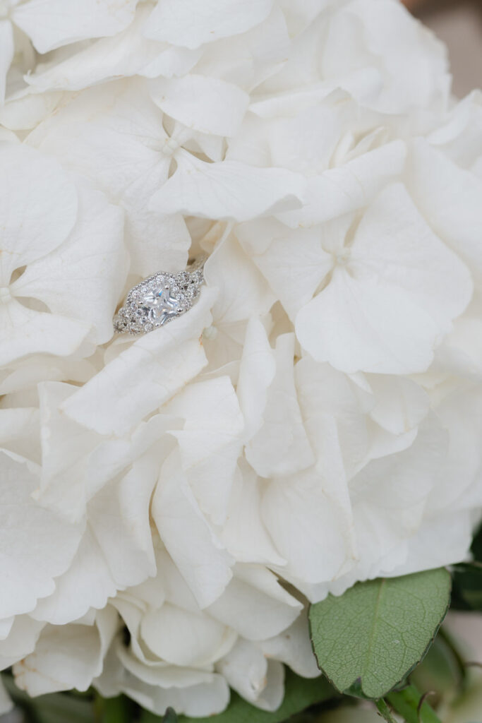 Detailaufnahme von einem Hochzeitsring auf einer weißen Hortensienblüte