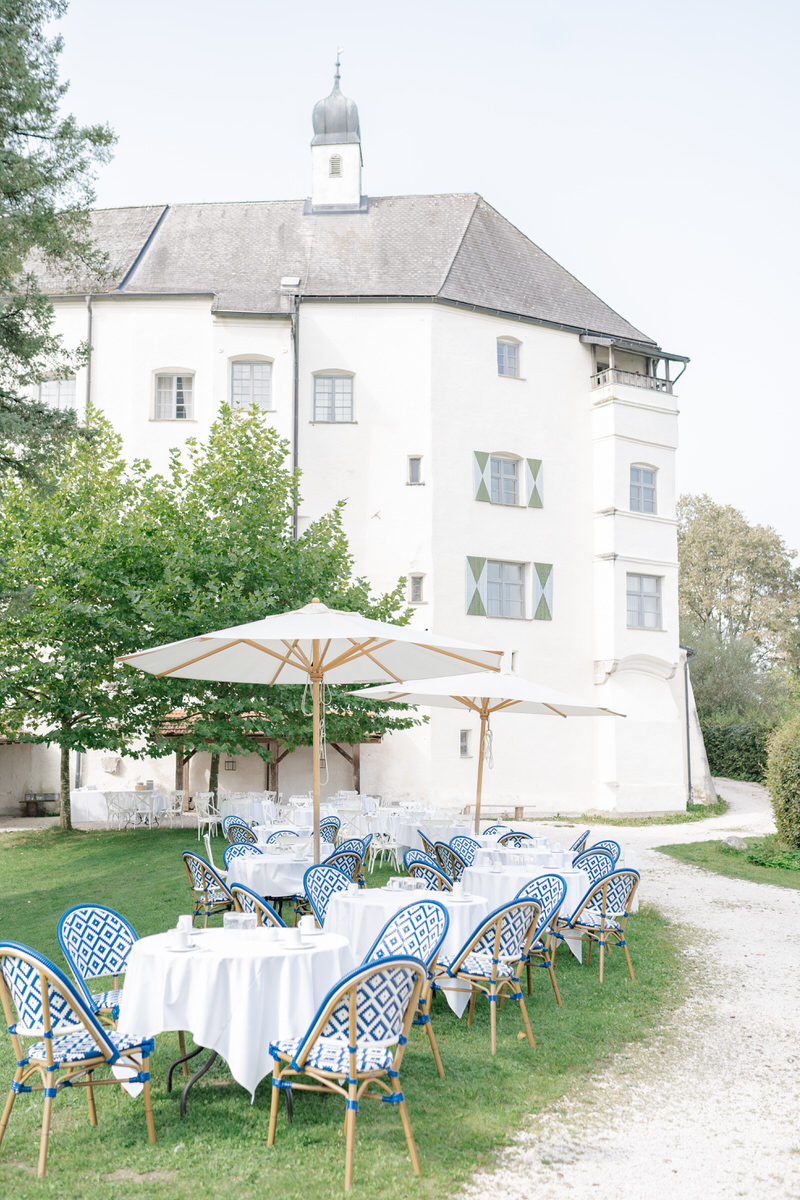 Sommerlich dekorierte Hochzeitstische in blau und weiß im Park von Schloss Amerang bei einer