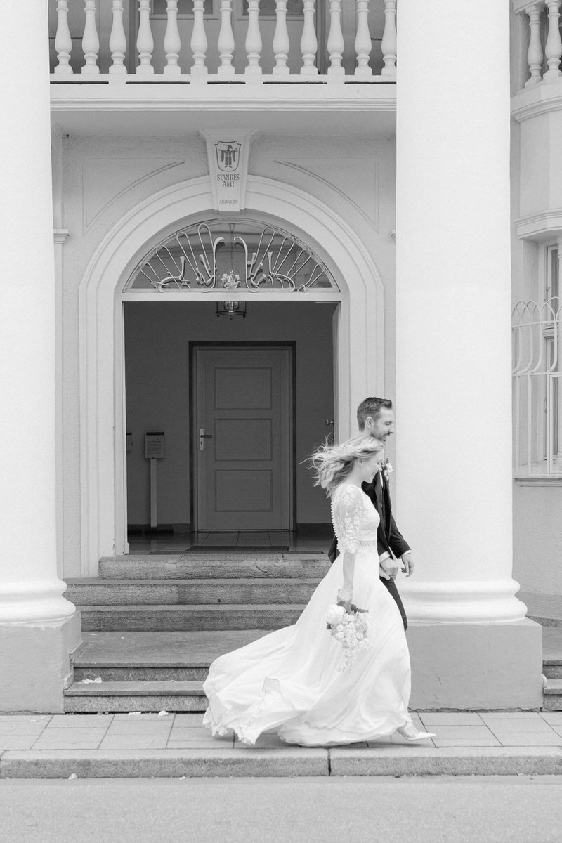 Spazierendes Hochzeitspaar nach ihrer standesamtlichen Trauung im Standesamt München
