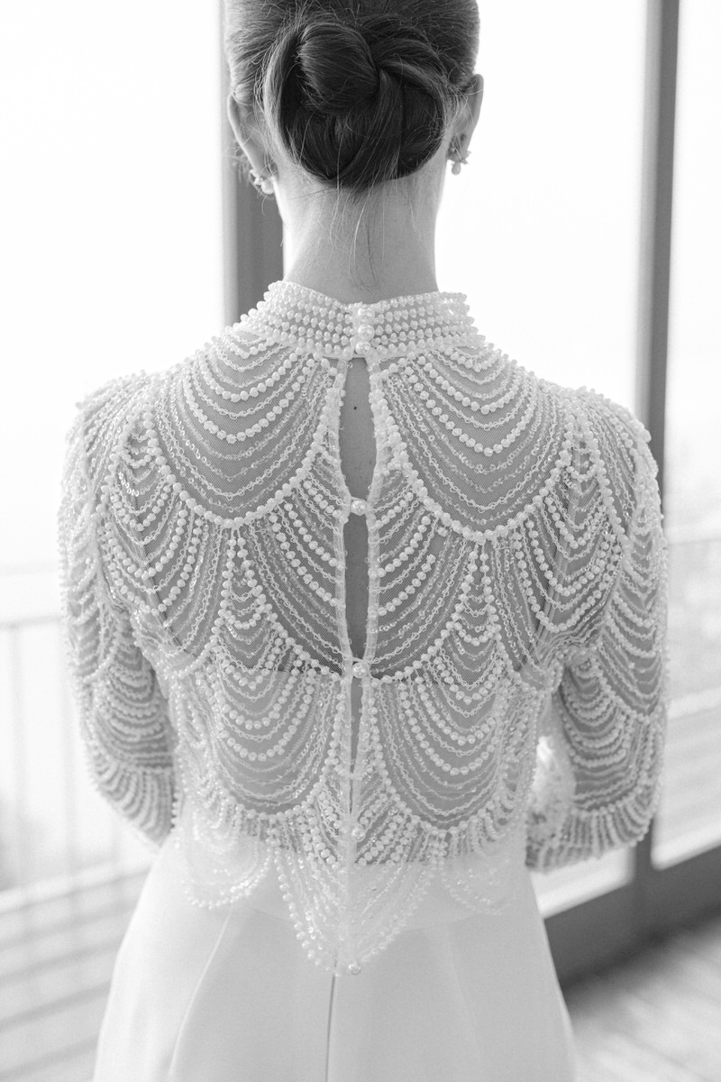 Rückenansicht einer Braut in einem Hosenanzug mit Perlenoberteil bei ihrer Hochzeit in Berchtesgaden in schwarz weiß fotografiert