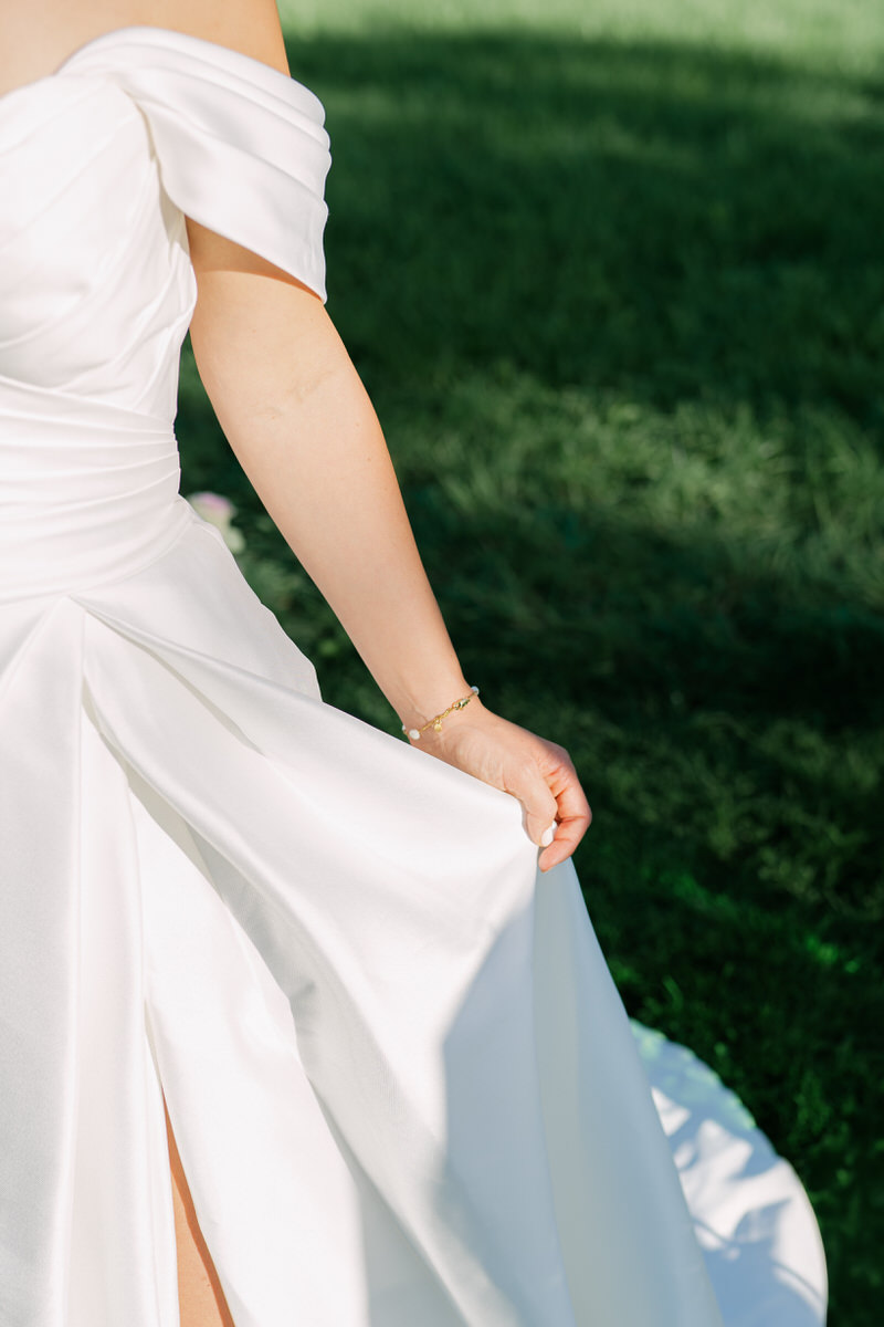 Detailaufnahme vom eleganten Brautkleid im Sonnenlicht bei einer freien Trauung