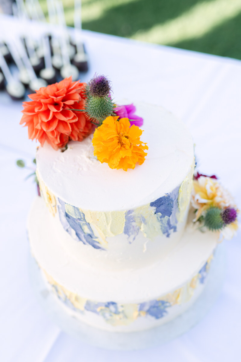 Zweistöckige Hochzeitstorte mit bunten Blumen bei einer Hochzeit im Rosenheimer Umland