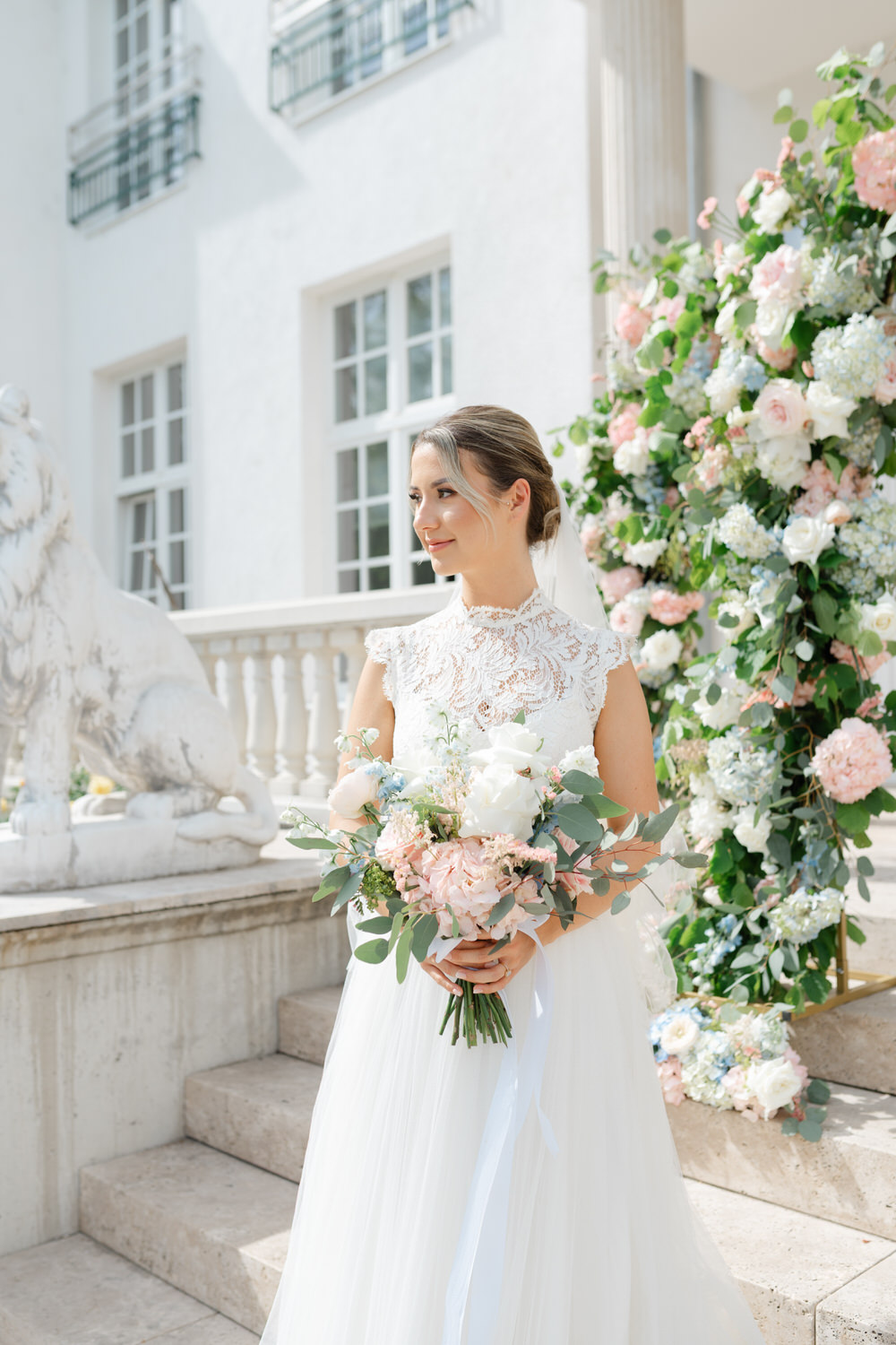 Eine Braut hält ihren Brautstrauß Händen und lächelt