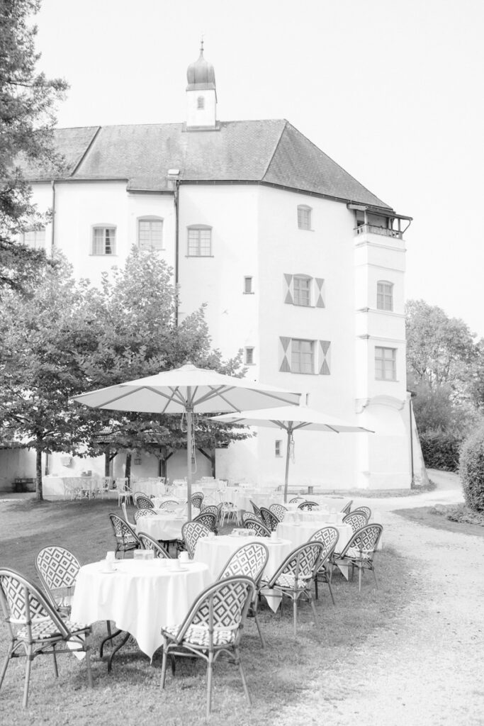 Festlich gedeckte Tische bei Hochzeitsfeier mit der Schlossfassade bei Amerang in schwarz weiß fotografiert