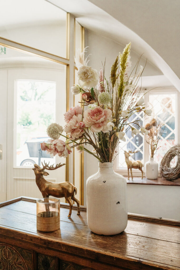 Blumen,dekoration und eines Skulptur im Flur des Hotel Lindner in Bad Aibling