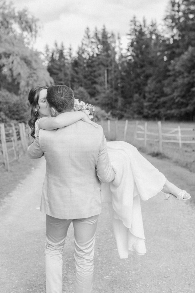 Bräutigam trägt Braut auf Händen bei Brautpaarshooting mit Hochzeitsfotograf Rosenheim