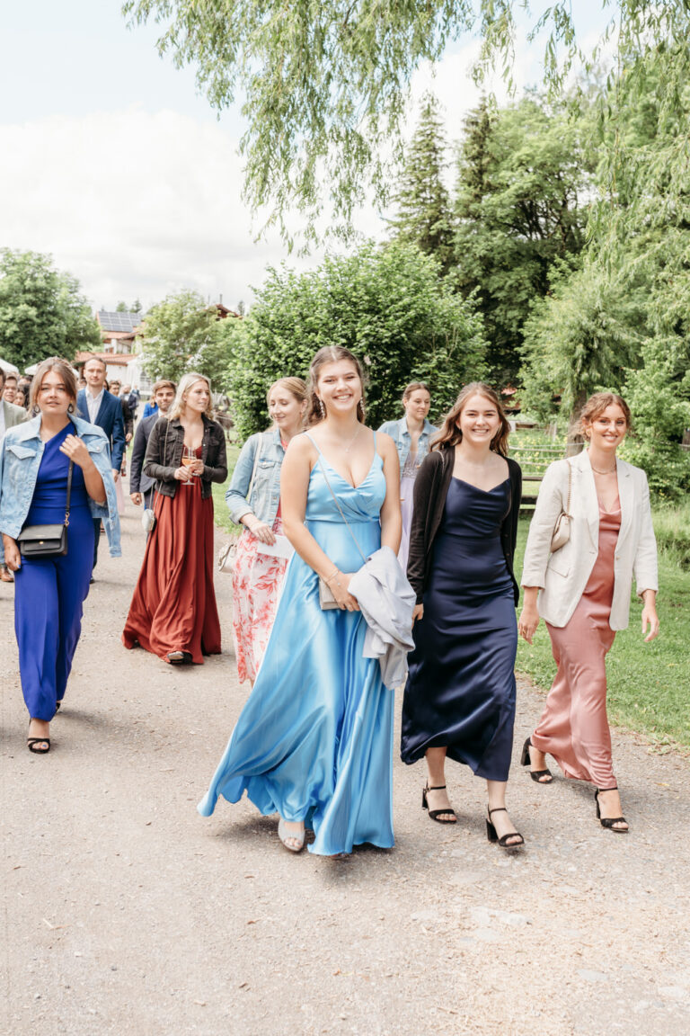 Hochzeitsgesellschaft bei einer Sommerhochzeit auf dem Weg zur freien Trauung
