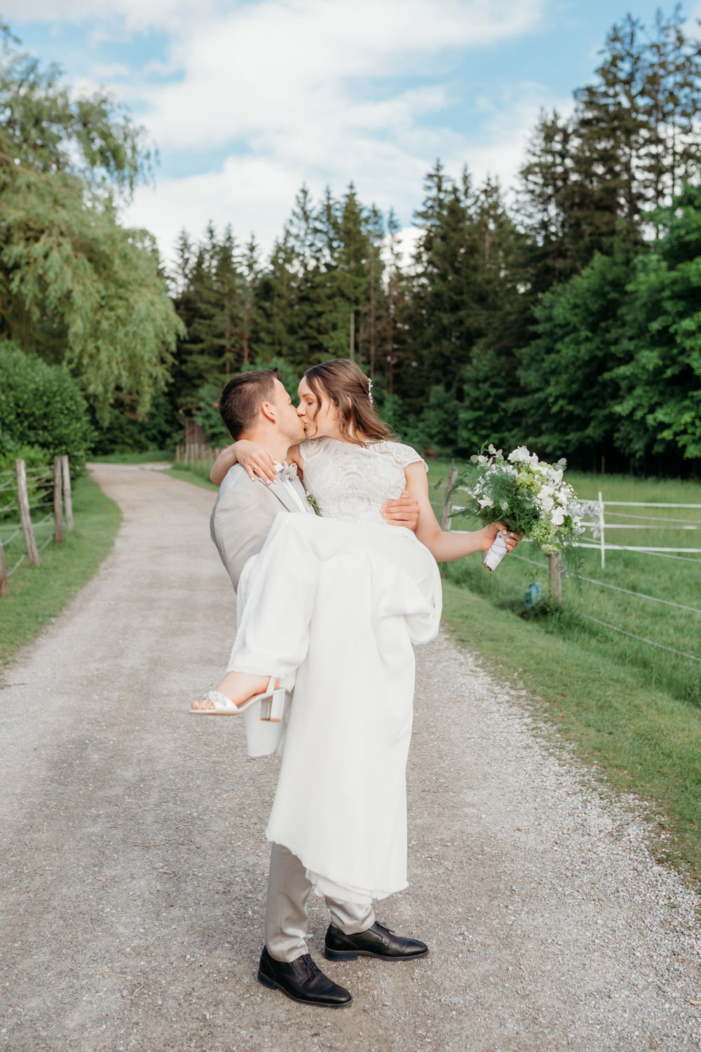 Bräutigam trägt Braut auf den Händen während einem romantischen Hochzeitsshooting in der Waldgaststätte Filzenklas bei Tuntenhausen